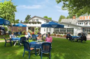a group of people sitting at tables in the grass at Hotel-Restaurant Faehr-Cafe in Niesgrau