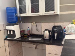 eine Küchentheke mit einer Spüle und einem Mixer in der Unterkunft Suíte casal 01 in Trindade + 3 Fotos