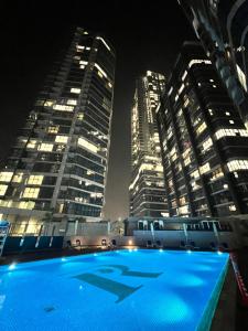 a swimming pool at night with tall buildings at Cozy Room In Abu Dhabi Reem island Near to Galeria Mall in Abu Dhabi