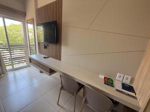 卡达斯诺瓦斯Flats Spazzio diRoma acesso ao Acqua Park的客房设有带椅子的书桌和电视。