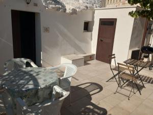a patio with a table and chairs in a room at Trullo Il Giglio in Cisternino +21 photos