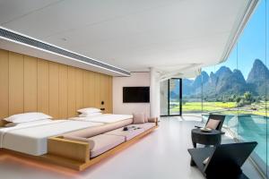 a bedroom with a large bed and a tv at Paddy Fields Resort-Guilin Shuidaotian in Yangshuo