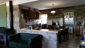 a kitchen with a bar with a couch and a table at Nossa Casa na Aldeia in Viseu