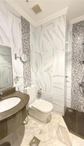 a white bathroom with a toilet and a sink at رتاج إن in Al Khansāk