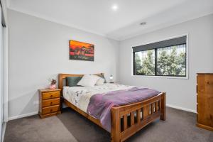 una camera da letto con un letto e una finestra di Alpine Corner - Lux and Quiet a Thurgoona