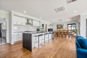 ThurgoonaAlpine Corner - Lux and Quiet的开放式厨房以及带蓝色沙发的客厅。