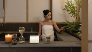 une femme prenant un bain dans une baignoire dans l'établissement Anook Ryokan Hotel Ansan station, à Ansan