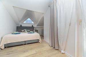 une chambre blanche avec un lit et une fenêtre dans l'établissement Gemütliche Ferienwohnung Tina 4, à Šilo