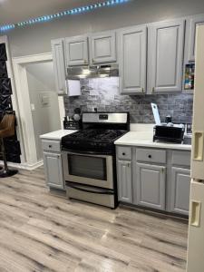 una cucina con fornelli e mobili bianchi di Your home away from home private bedroom near EWR and NYC a Elizabeth