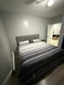 una camera da letto con un letto con un piumone a righe di Your home away from home private bedroom near EWR and NYC a Elizabeth