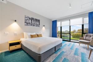 a hotel room with a bed and a chair at MJ McMahon Motel in Wonthaggi