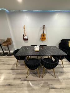 un tavolo con sedie in una stanza con chitarre sul muro di Your home away from home private bedroom near EWR and NYC a Elizabeth Altre 18 foto