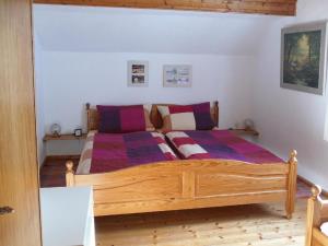 a bedroom with a wooden bed with purple sheets at Ferienwohnung Nationalparkblick in Spiegelau