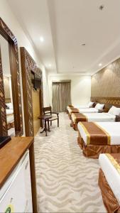 a hotel room with several beds and a television at رتاج إن in Al Khansāk