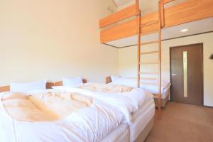 En eller flere senge i et værelse på リゾートペンション四季彩