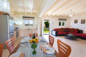 eine Küche und ein Wohnzimmer mit Tisch und Stühlen in der Unterkunft Haus In Kolympia Mit Parkplatz Und Bergblick in Kolymbia