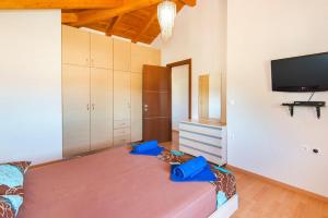 ein Zimmer mit einem Bett und einem Flachbildfernseher in der Unterkunft Haus In Kolympia Mit Parkplatz Und Bergblick in Kolymbia + 26 Fotos