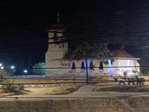 un edificio bianco con torre dell'orologio di notte di Kapricho Wanka a Huancayo