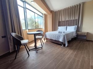 una camera da letto con un letto, un tavolo e delle sedie di Kapricho Wanka a Huancayo