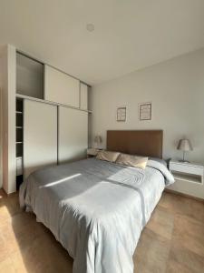 een witte slaapkamer met een groot bed. bij Lobos de Mar IV in Ostende