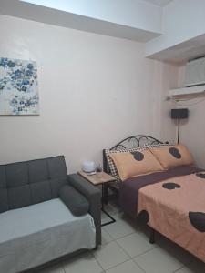 a living room with a bed and a couch at The Grand Towers Manila in Manila +7 photos