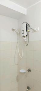 a bathroom with a shower with a phone on the wall at The Grand Towers Manila in Manila