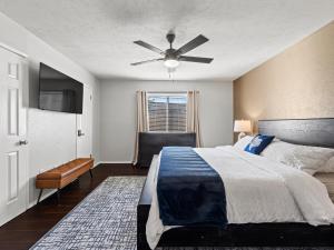 une chambre avec un lit et un ventilateur de plafond dans l'établissement Red Door Hideaway 3bd, Hot Tub, Foosball, à The Colony