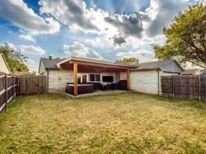une maison avec une arrière-cour dotée d'une clôture dans l'établissement Red Door Hideaway 3bd, Hot Tub, Foosball, à The Colony