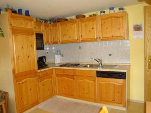 une cuisine avec des armoires en bois et un évier dans l'établissement Ferienwohnung Wiesengrund In Bayerisch Eisenstein, à Bayerisch Eisenstein 18 autres photos