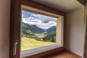 a window with a view of a golf course at Monte Campell Dasura in Poschiavo