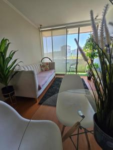 un soggiorno con un divano e alcune piante di Providencia Hermoso depto de 2 Dorm 2 B wifi y parcking Gratis a Santiago