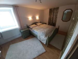 ein kleines Schlafzimmer mit einem Bett und einem Fenster in der Unterkunft Ferienwohnung für 4 Personen ca 68 m in Kirchdorf im Wald, Bayern Bayerischer Wald in Kirchdorf im Wald