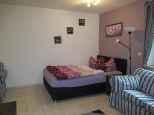 ein Schlafzimmer mit einem Bett, einer Couch und einem Sessel in der Unterkunft Großzügiges Ferienstudio für zwei Personen in Weißenstadt