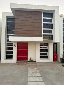 een rode deur op een gebouw met een rode garage bij New House Near The Beach in Ensenada