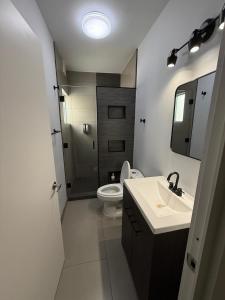 een witte badkamer met een toilet en een wastafel bij New House Near The Beach in Ensenada