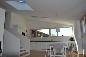 eine Küche mit weißen Schränken und einem Tisch und Stühlen in der Unterkunft Haus Sonneninsel Velden am Wörthersee in Velden am Wörthersee