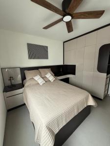 a bedroom with a bed with a ceiling fan at New House Near The Beach in Ensenada
