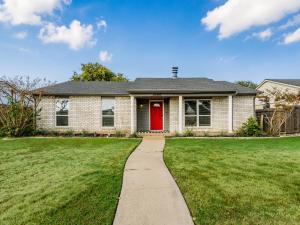 une maison avec une porte rouge et une cour d'herbe dans l'établissement Red Door Hideaway 3bd, Hot Tub, Foosball, à The Colony