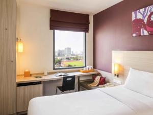 Una habitación de hotel con una cama, un escritorio y una ventana. en ibis Bangkok Siam, en Bangkok 34 fotos más