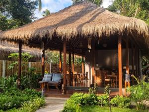 a hut with chairs and a straw roof at Ananda B&B in Gili Air