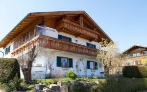 a large white house with a wooden roof at Morgensonne in Lechbruck