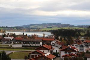 a town with houses and a lake in the background at Morgensonne in Lechbruck +27 photos