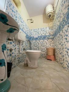 a bathroom with a toilet and blue and white tiles at The Founder's Tribe in Bīr +20 photos