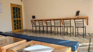 a row of bar stools in a room with a table at The Founder's Tribe in Bīr