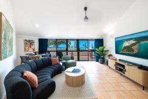 un soggiorno con un divano blu e una TV di Bella Isola ad Airlie Beach