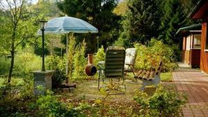 a chair and an umbrella in a garden at Ferienhaus Mit Bergblick in Harztor