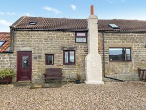 a brick house with a bench in front of it at Bay - Uk44720 in Ravenscar