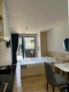 a bedroom with a bed and a table and chairs at The Ló Apartment in Kon Rung (1)