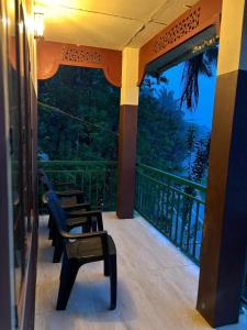 Un porche con dos sillas y un balcón con vista. en Chillwind Service villa, en Padinjarathara