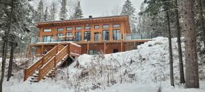 een huis in het bos in de sneeuw bij Chalet L'Orée Étoilée in La Tuque